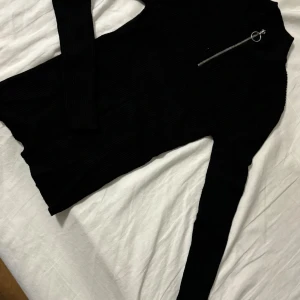 Svart långärmad tröja med dragkedja - Säljer en stilren svart långärmad tröja med en cool dragkedja vid halsen. Perfekt för både vardag och fest! Tröjan är i bra skick och passar till det mesta i garderoben.