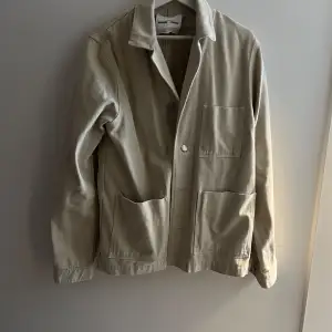 Overshirt jacka/tröja. Använd fåtal gånger och i väldigt bra skick. Färgen heter Rainy Day men den är beige och det syns bra på bilden. Storlek M men har annars bara L så ganska stor så större i storleken. Originalpris 1800.