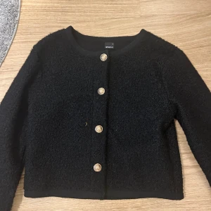 Svart kofta  - Svart lurvig kofta med guldiga knappar från Gina tricot❤️ den har använts 2 gånger och är normal i stoleken