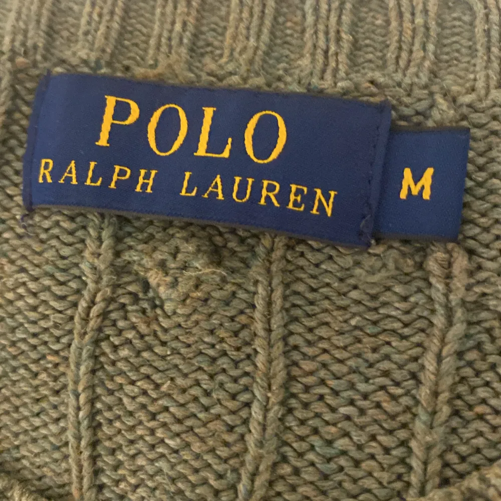 Säljer en snygg grön stickad tröja från Polo Ralph Lauren. Den är i storlek M och har ett klassiskt kabelstickat mönster. Tröjan är tillverkad i 100% silke vilket gör den supermjuk och lyxig. Perfekt för höst och vinter!. Tröjor & Koftor.