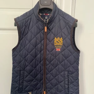 Quiltad väst från Morris - Snygg mörkblå quiltad väst från Morris. Västen är i mycket bra skick. 