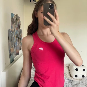 Rosa linnetopp från Nike - Säljer en snygg rosa linnetopp från Nike Air. Perfekt för träning eller en varm sommardag. Toppen är ärmlös och har en tight passform med det klassiska Nike-loggan i vitt på bröstet. Superbekväm och stilren!