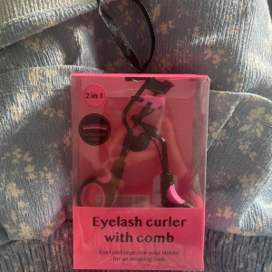 Ögonfransböjare med kam - Säljer en 2-i-1 ögonfransböjare med inbyggd kam för att böja och separera dina fransar för en fantastisk look. Den kommer i en snygg rosa förpackning och är perfekt för att få till den där extra wow-effekten på dina fransar!🩷