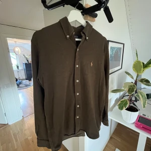 Ralph Lauren skjorta - Skjortan är en fin grön färg den är använd 3 ggr alltså är den i nyskick. Jag säljer den pga att den är för kort för mig. Den har S men kan också funka för M hör av er om ni vill veta mer om storlek osv. Köpt på Nordlunds i växjö för 1849kr 