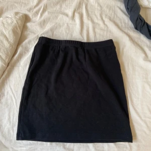 Svart kjol - Säljer en enkel och stilren svart kjol. Perfekt för både vardag och fest. Den har en normal passform och är gjord i ett mjukt och bekvämt material.