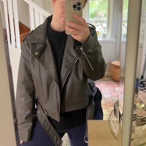 Skinnjacka grön -  supersnygga jacka i skinnimitation. Biker modell, mörkgrön. Den har spännen som man kan knäppa runt midjan, fickor och dragkedja längst ner vid ärmen. Har aldrig använts. Stor i storleken!  Nypris 699kr🍁💚