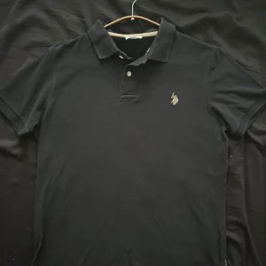 US polo skjorta - I perfekt skick. Storlek M Mått från bottnet till sidan av halsen är 64cm Måttet ax axlarna är 44cm Grisch, laidback, stockholmsstil