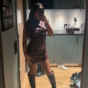 Vinröd klänning - Snygg vinröd klänning i kort modell med en elegant och stilren design. Perfekt för en kväll ute eller en speciell tillställning. Klänningen har en figurnära passform som framhäver silhuetten. Använd en gång! 