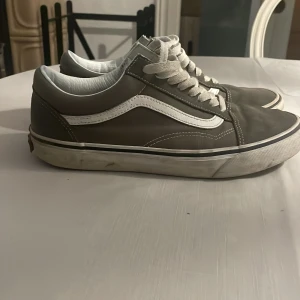 Grå sneakers från Vans - Säljer ett par klassiska grå sneakers från Vans med vit sula och snörning.Nypris 999 kr säljer de endast för 400 kr priset kan sänkas vid en snabb affär,skon är i 8/10 skick o väldigt sköna 