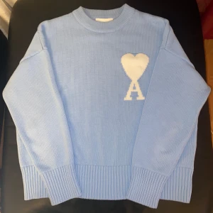 Ami Paris  - Säljer en snygg och stilren Ami Paris tröja i ljusblått, med det ikoniska Ami de Cœur-logotypen broderad   på bröstet.  ✅ Storlek: M ✅ Färg: Ljusblå ✅ Skick: Helt ny ✅ Nypris: Ca 2 500-4 000kr  Perfekt för en avslappnad men samtidigt trendig look!  Säljer denna tröja då min mormor köpte en för liten storlek.  Skicka ett meddelande vid intresse. Snabb affär = snabb leverans!