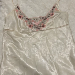 Vit sidenklänning från Secret🤍 - Natt linne från Secret Possessions. Den har vacker blommig spetsdetalj i rosa och brunt vid halsringningen. jätte söt!!🩷