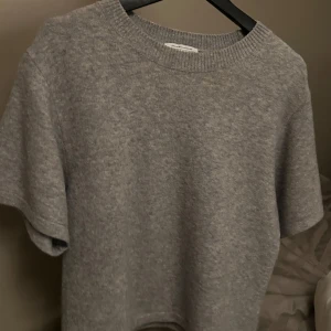 GRÅ STICKAD T-SHIRT OTHERSTORIES - Säljer en stilren grå stickad tröja från & Other Stories. Mycket bra skick och är sparsamt använd!