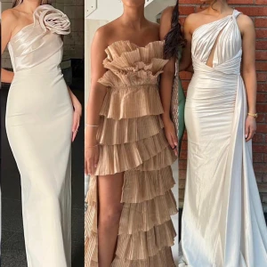 Tre eleganta klänningar - Utforska tre fantastiska klänningar: en axelbandslös vit långklänning med en stor blomdetalj, en beige volangklänning med flera lager och en vit oneshoulder långklänning med draperad design och slits. Klänningen längst till vänster är i storlek 42(mitten såld) (längst till höger såld)