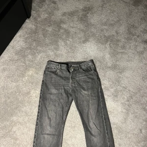 Grå jeans Weekday Space - Snygga grå jeansbyxor med en klassisk straight passform. De har en dragkedja och knappar framtill. Perfekta för en avslappnad stil. Storlekslappen är borta men samma storlek som mina andra jeans, 31-32.