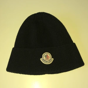 Moncler mössa - Snygg svart stickad mössa från Moncler med broderad logotyp framtill. Perfekt för att hålla värmen under kyliga dagar. Klassisk design som passar till det mesta. Jag köpte den förra vintern från kicks, jag har bara använt den ett par gånger eftersom jag inte vill att den ska bli sliten. Jag har inte kvittot kvar men jag lovar att den är äkta. (Pris kan diskuteras, fråga för minsta lilla tanke!)