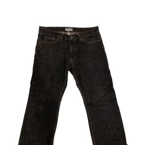 Svarta RedWood Jeans - Snygga svarta jeansbyxor från RedWood Jeans med klassisk femficksdesign och knappgylf. Perfekta för en stilren look. Passar bra till både vardag och mer uppklädda tillfällen.