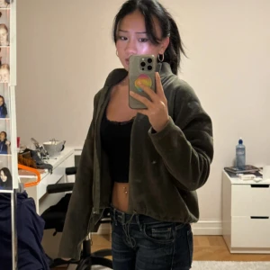 Grön fleecejacka - Säljer en mysig grön fleecejacka med dragkedja. Jackan har en avslappnad passform och långa ärmar, perfekt för kyliga dagar. Den är enkel att matcha med olika outfits och ger en skön känsla.