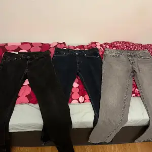 Säljer tre par jeans i olika färger. Ett par svarta, ett par mörkblå och ett par ljusgrå. Alla har klassisk femficksdesign och knappgylf. Perfekta för en avslappnad stil.