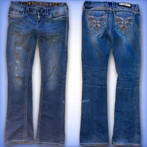 Rock Revival jeans - Ett par fina rock revival jeans med en del skador, färg på främre låren, och några bokstäver borta på patchen.                                                                      Innerbenslängd: 80cm💙.                                                Midjemått tvärs över 39cm💙