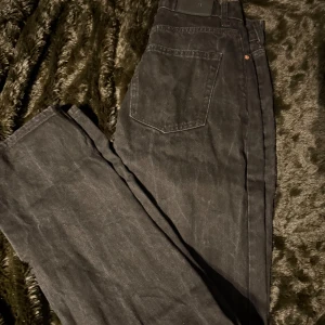 Svarta jeansbyxor från Gina Tricot  - Snygga svarta jeansbyxor från Gina Tricot med klassisk femficksdesign och knappgylf. Perfekta för en stilren look.