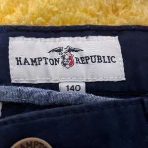 Mörkblå byxor från Hampton Republic - Snygga mörkblå byxor från Hampton Republic i storlek 140. Byxorna har en klassisk design med knappar och dragkedja framtill. Perfekta för en stilren look.