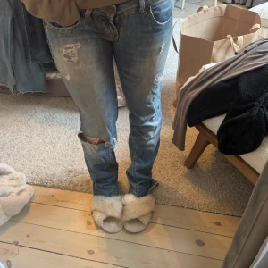 Jeans  med slitningar low waist - Säljer ett par blå jeans med slitningar, flare o väldigt low waist  suuuper fina verkligen med fickorna