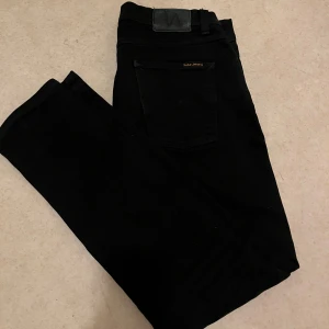 Svarta jeans ifrån nudie jeans - Ett par riktigt snygga svarta Nudie Jeans i den trendiga modellen Lean dean. Skick 9/10.   Storlek: W33/L32. Hör gärna av er vid frågor!