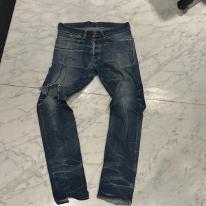 Extremt slitna selvedge jeans - Snygga blå jeans med slitningar och en cool, sliten look. De har en klassisk femficksdesign och är perfekta för en avslappnad stil. Jeansen har en rak passform och är tillverkade i denim. För att va exakta på japanska shuttle looms (selvedge). Säljer på grund av för många slitningar. Tipsar för den som gillar att laga kläder! Pris kan diskuteras väldig lågt.