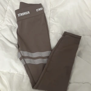 hero tights STRONGER S - endast tvättade en gång och aldrig använda, org. pris 700kr. 🩷färgen är typ beige/grå/brun, svårt att beskriva 😅första bilden är i takbelysning, andra bilden är i dagsljus, sista bilden för close up på färgen. TROR färgen är ”Cinder” på deras hemsida! 