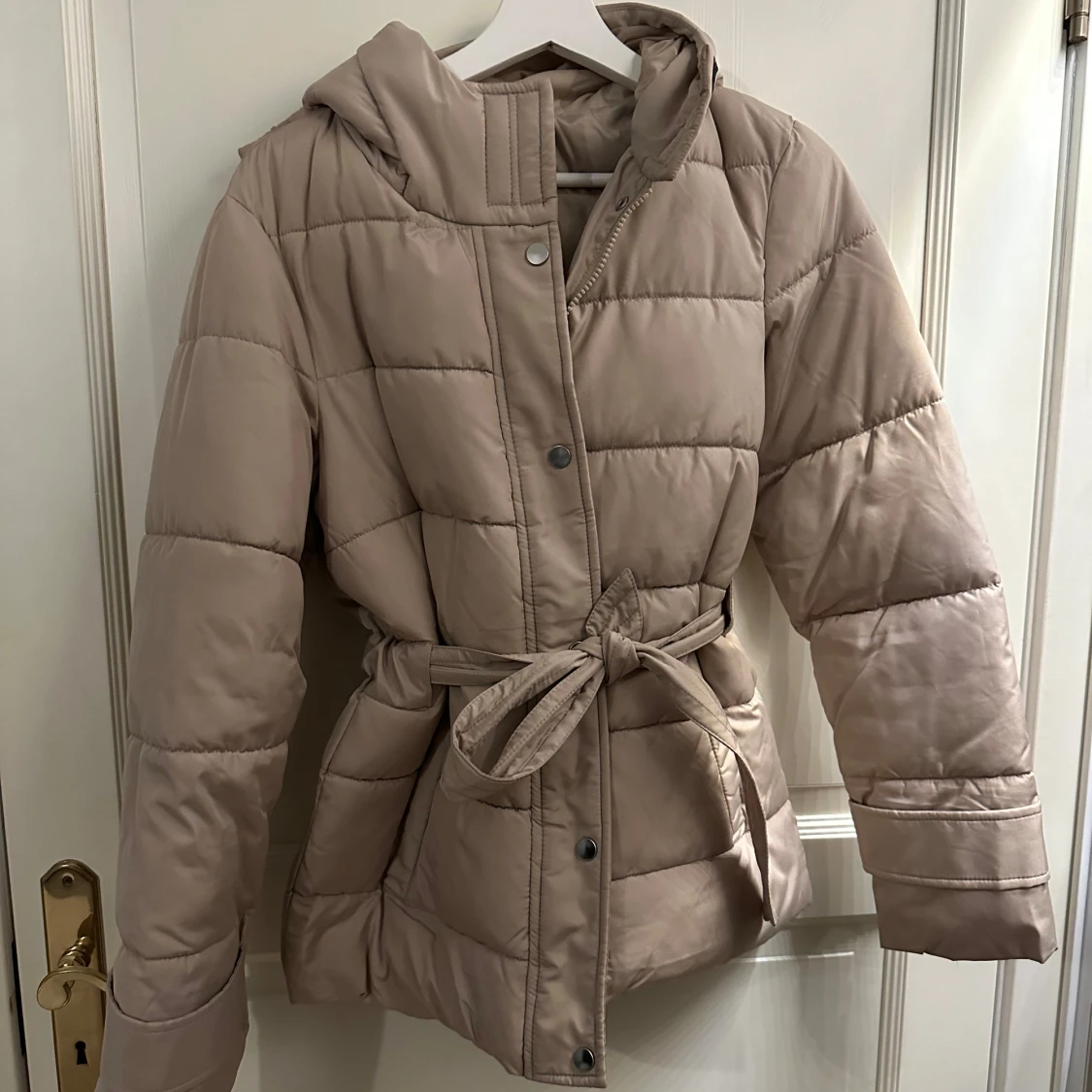 Beige quiltad pufferjacka med bälte