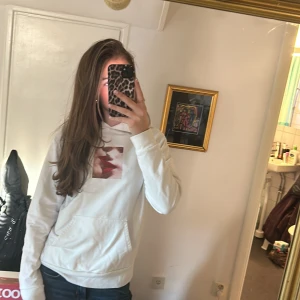 Vit hoodie med tryck från STAY - Säljer en supercool vit hoodie från STAY i storlek S. Den har ett unikt tryck av röda läppar på framsidan som verkligen sticker ut. Perfekt för en avslappnad stil och passar till allt. Hoodien är i bra skick men liten i storleken så passar xs/xxs