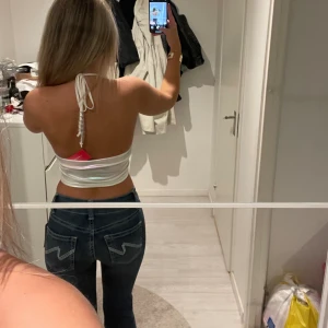 Skimmrig/glansig topp - Topp från shein, vet inte vad de är för material de är glansigt💞i storlek XS, man knyter den runt halsen, på banden är de pärlor, väldigt fin vet bara inte när jag ska använda, prislapp på