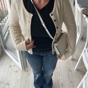 Beige axelväska - Säljer en superfin beige/ gammaldags vit kofta i jättefint material! Älskar den men den är lite liten för mig. Den är från New house och är i storlek S. Den har ett litet hål på ärmen som knappt syns men därav billigare pris💞