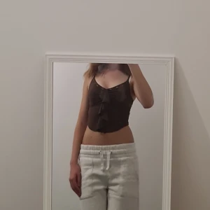 Unik brun topp - As cool "going out" topp med en volang och sånna typ hål (vet inte vad dom heter men kolla bilden haha) från märket the kript. Köpt för 350, I ny shick. Skriv vid frågor!