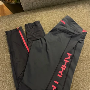 Kari traa träningstights  - Snygga träningstights i mörkt blått med rosa detaljer från Kari traa i storlek M  Tightsen har ett snyggt mönster på benen och en rosa logga på höger ben. 