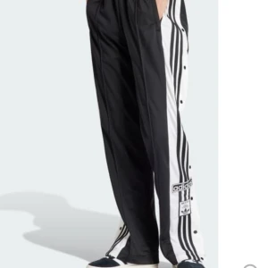Adidasbyxor med knappar på sidan - Adidas adibreak. Storlek S/M beroende på hur man vill att de ska sitta. I väldigt fint skick. Går att knäppa upp knapparna på sidorna. 