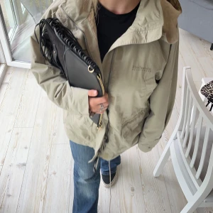 Beige vindjacka från Didriksons - Säljer en beige/grön vindjacka från Five Season. Den har en dragkedja framtill och huva. Den är i bra skick men behöver sälja för rensar!💞 perfekt till hösten🤗