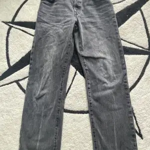 Säljer ett par klassiska grå Levis 501 jeans. De har en straight passform och är tillverkade i slitstarkt denim. Perfekta för en casual look och passar till det mesta. De är i bra skick och redo för en ny ägare!