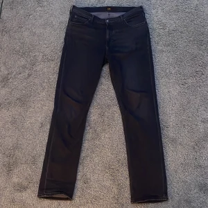 Svarta jeans från Lee - Snygga svarta jeans från Lee med en klassisk design. De har en slim passform och är 34w 34l. Använda 1 gång