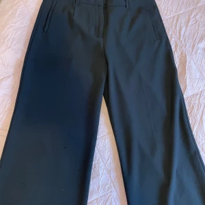 Svarta kostymbyxor från Stockh LM - Snygga svarta kostymbyxor från Stockh LM i storlek 40. Byxorna har en klassisk design med raka ben och diskreta fickor. Perfekta för en stilren look.