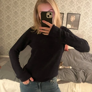 Mörkblå långärmad tröja - Säljer en stilren mörkblå långärmad tröja. Perfekt för kyligare dagar och enkel att matcha med olika outfits. Tröjan har en klassisk design med rund hals och är tillverkad i ett mjukt material.