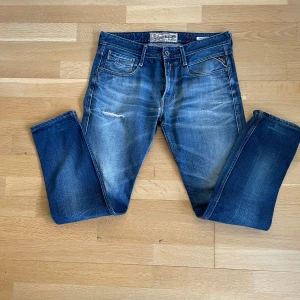 Blåa jeans från Replay - Schyssta Replay Anbass jeans som aldrig används. Dessa är storlek 34:34. Jeansen har en klassisk blå färg som passar med flera andra plagg. Jeansen har en modern look för ens vardag. Om det finns frågor är det bara att ställa de!