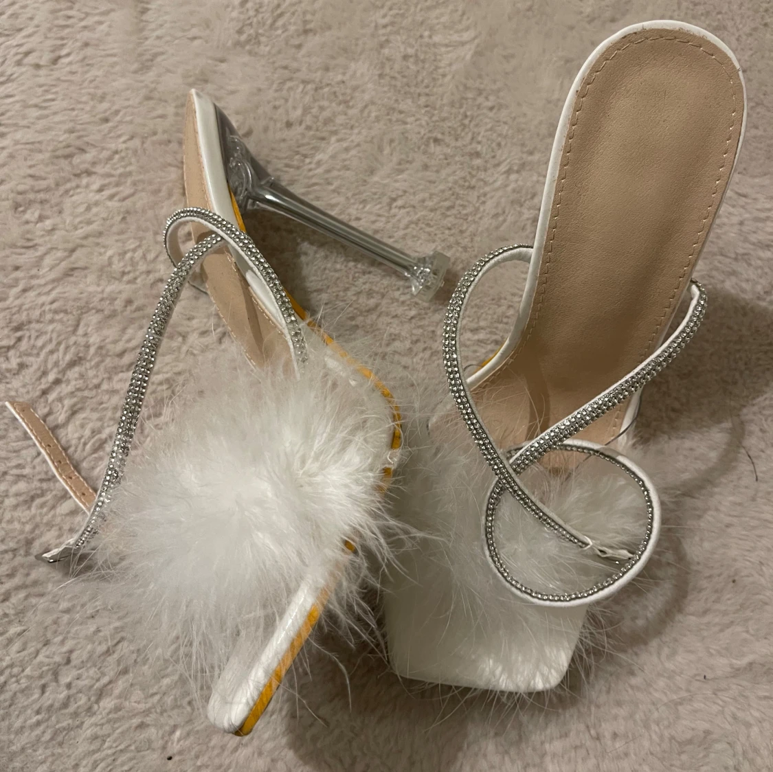 Vita klackskor med fjäderdetalj