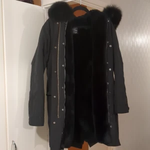 Svart parkajacka med pälsdetaljer - Passform: S/M