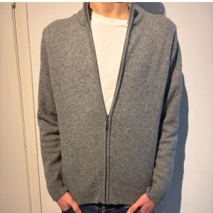 Grå full zip tröja - Säljer en riktigt snygg grå merinoull helzipp tröja från märket Camargue. Storlek M, bra skick hör ev er vid eventuella frågor!