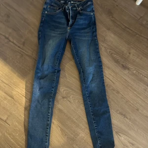 Blå jeans med snörning - Snygga blå jeans med snörning i midjan. De har en klassisk design med en modern twist och är perfekta för en avslappnad stil. Passar bra till både sneakers och kängor.