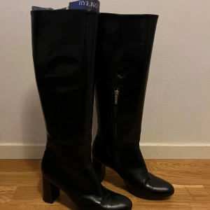 Svarta boots med dragkedja - Snygga svarta boots i skinn med dragkedja på sidan från Rylko. Nypris ca 2000kr. Sparsamt använda. Klack:7cm. Runt skaftet:39cm