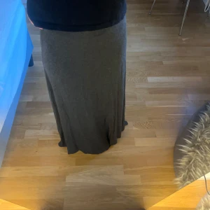 Grå långkjol - Snygg och bekväm grå långkjol i mjukt material. Perfekt för en avslappnad stil. Kjolen har en enkel design som gör den lätt att matcha med olika toppar.