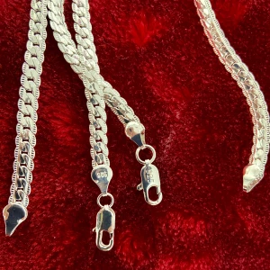 Silverpläterad halsband med armbandet, 925 silver - En ny halsband vacker silver pläterad kedja sterling 925, med armband kedja i utsökt design med mycket tyngd i och med mycket glans, silverpläterad 925 stämplad. Kedjan är mycket vacker och är kvadratisk. Vikt ca 22 gram, längd 50cm och tjocklek 5mm. I nyskick • längd 50cm • bredd 5mm • 22 gram • sterling 925 • Armband 21cm • bredd 5mm