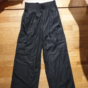 Svarta cargobyxor från Oysho - Snygga svarta cargobyxor från Oysho med elastisk midja och flera praktiska fickor. Perfekta för en avslappnad stil med en loose passform.